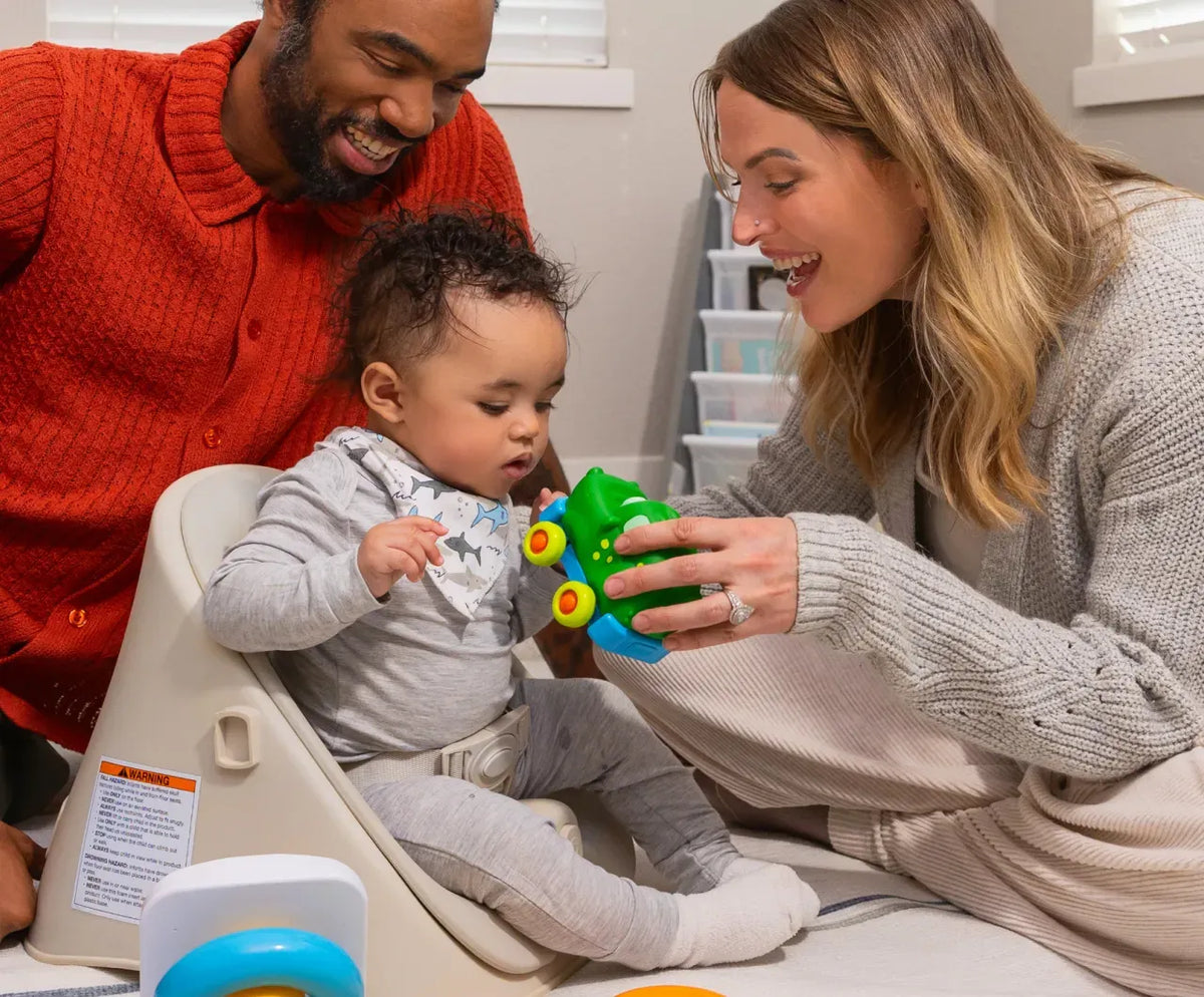 Mutli-racial family using the Baby Proper Posture Baby seat during playtime.